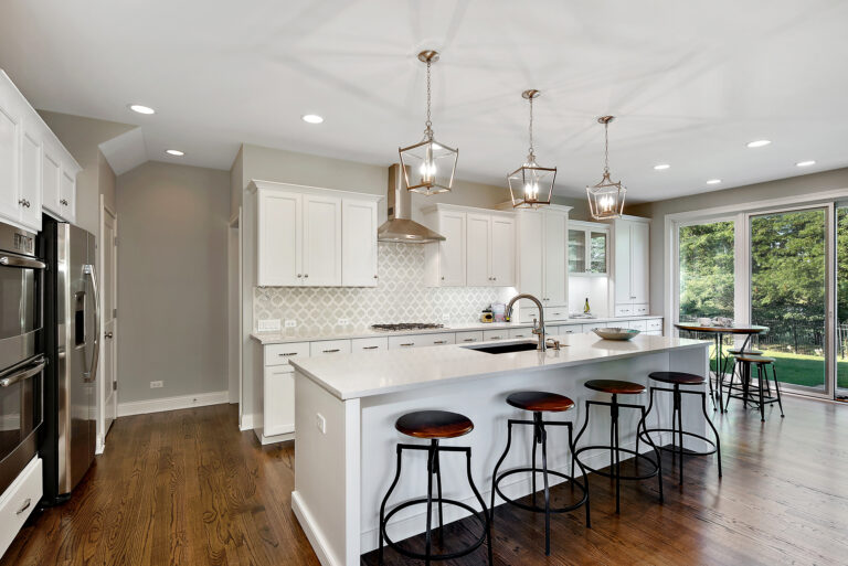 Pendant lights hang above kitchen island in open floor plan